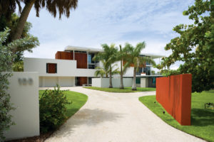 The single-story Revere Quality House, at right, built in 1947 at 100 Ogden Lane on Siesta Key, was restored in 2008, when an elevated two-story house, designed by Guy Peterson, was built. The property represents the beginnings of midcentury modern architecture in Sarasota and the current state of the art. Courtesy photo.
