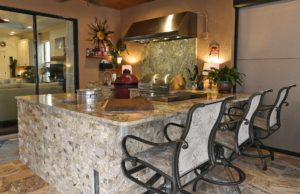 A view from the swimming pool to Russ and Tracy Spengler's outdoor kitchen. The bar is clad in stacked travertine and the counter is granite. The floors are travertine. Retractable opaque screen walls descend at night for privacy or when high winds or driving rain threatens to spoil a party. (July 8, 2016; STAFF PHOTO / THOMAS BENDER)
