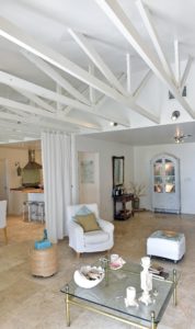 The living room in the 1970s ranch that Nathalie and Francis deWolf converted into a British-inflected beach cottage. Their boldest renovation project was bringing the eight-foot ceilings up to 12 by tearing out the ceiling and exposing the roof joices and painting them white for an industrial-rustic look. (July 28, 2016) (Herald-Tribune staff photo by Thomas Bender)